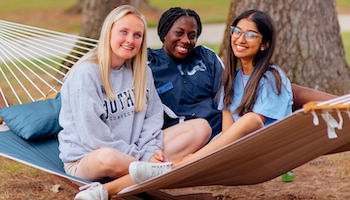 A group of three student in a university residential quad