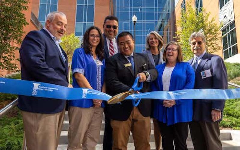 "University administrators cutting a ribbon at the ribbon-cutting ceremony"