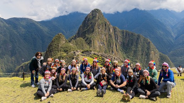 Students at Peru, a spanish-speaking country, with mountains in the background