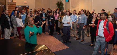 A large number of students and faculty in a banquet setting