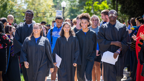 Spanish students in academic robes walking on campus