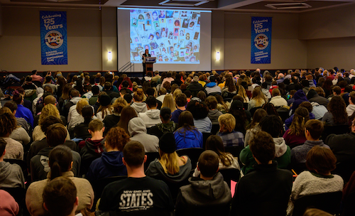 A presenter in front of large audience